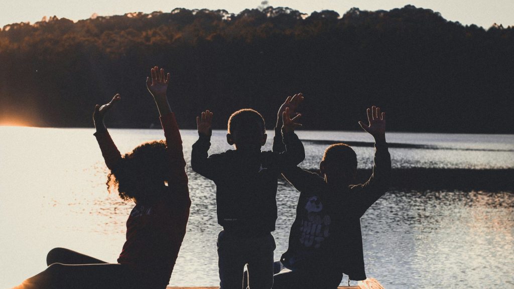 a group of people sitting on top of a wooden dock